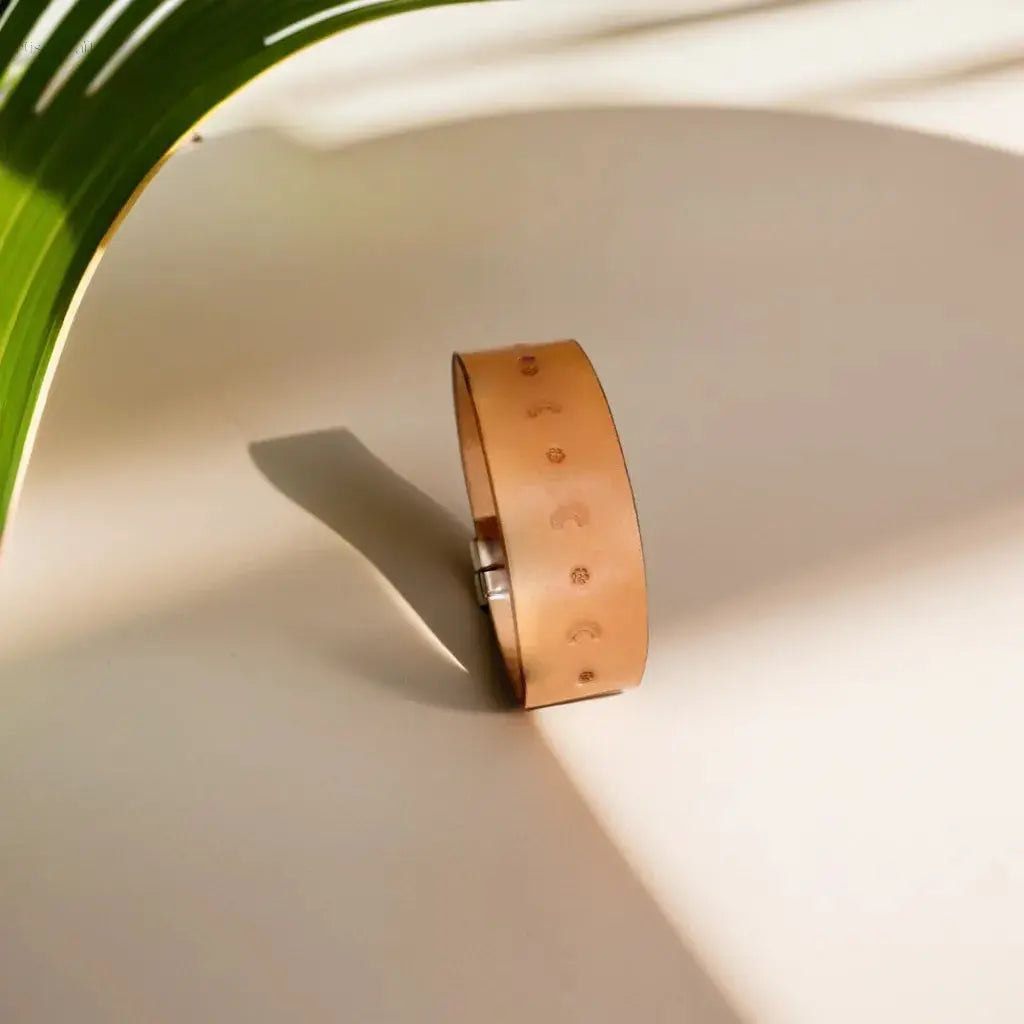 Hand-tooled leather bracelet in natural tan with flower-stamped design, perfect for gifting or daily wear